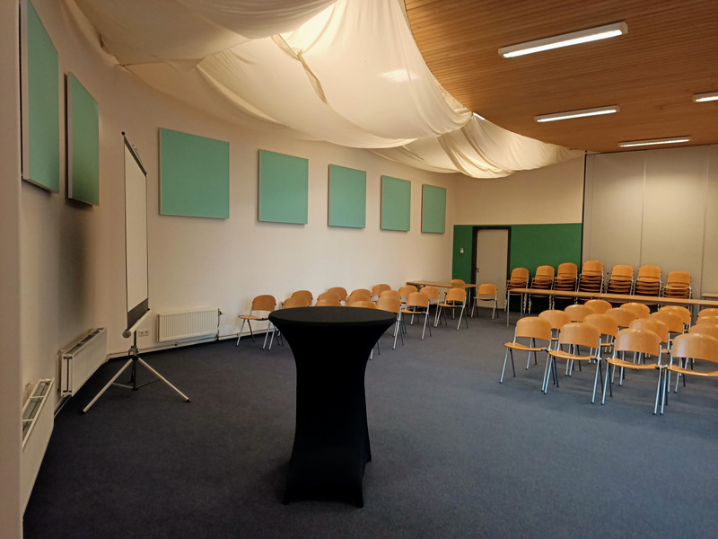 Vanuit perspectief van de organisatie zicht op het linker gedeelte van de zaal met een aantal stoelen van het publiek zichtbaar Vanuit perspectief van de organisatie zicht op het linker gedeelte van de zaal met een aantal stoelen van het publiek zichtbaar